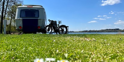 Campingplätze - Sauna - Eriba Wohnwagen am Seestellplatz mit Fahrrädern und Gänseblümchen - Camping Stein